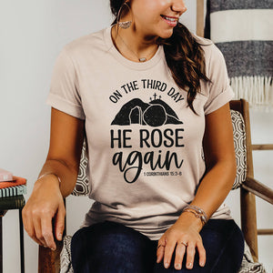 Seated woman wearing the He rose again t-shirt ahead of Easter