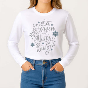 White long-sleeve shirt with 'Let Heaven and Nature Sing' text and snowflake graphics, worn by a person.