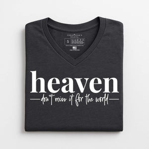 Folded black t-shirt with 'heaven don't miss it for the world' text on a white background