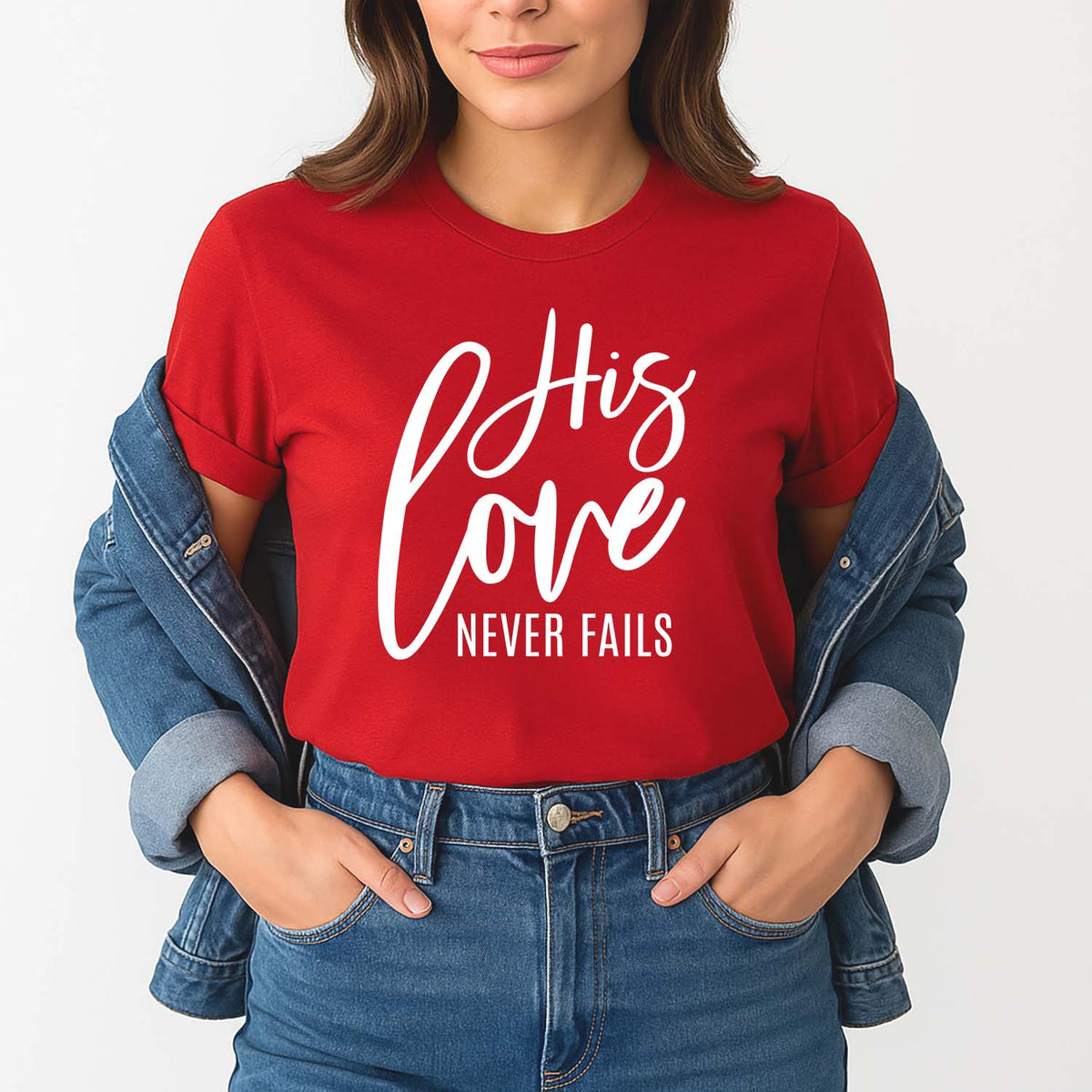 Woman wearing a red shirt with 'His love never fails' text, standing against a white background