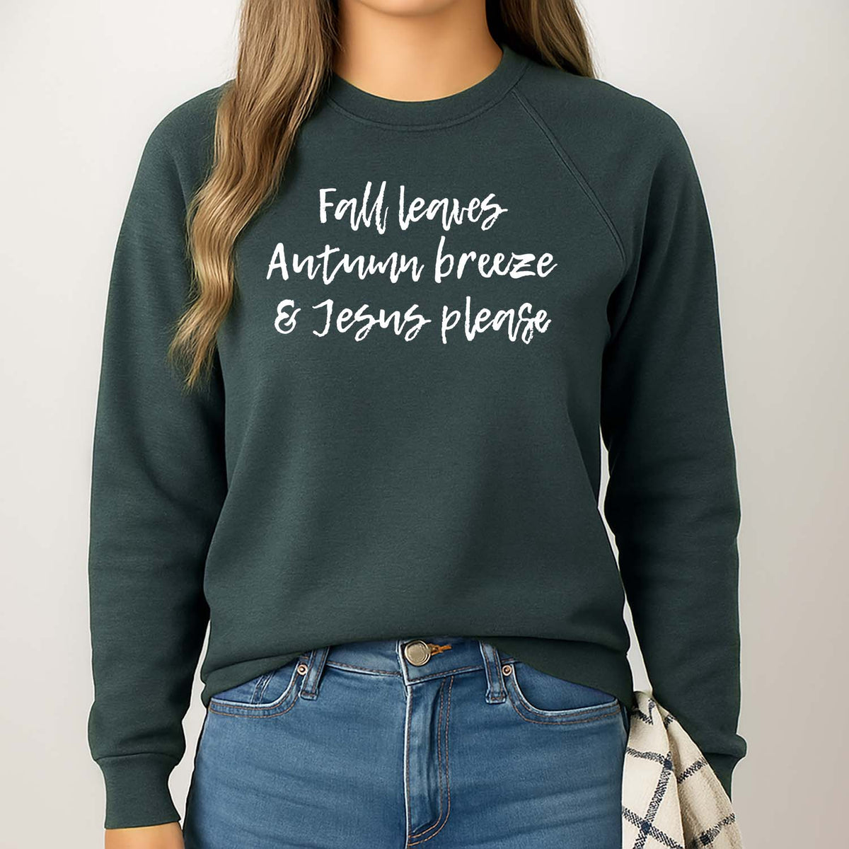 Girl wearing a dark green sweatshirt with a Chrisian quote about autumn