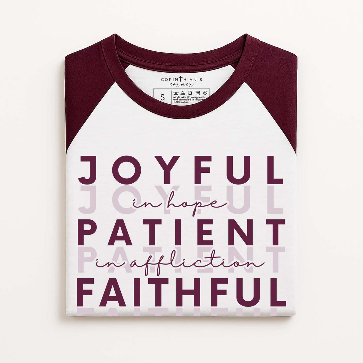 Maroon and white baseball shirt that reads joyful in hope, patient in affliction, faithful in prayer