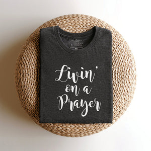 Folded grey t-shirt that reads livin' on a prayer