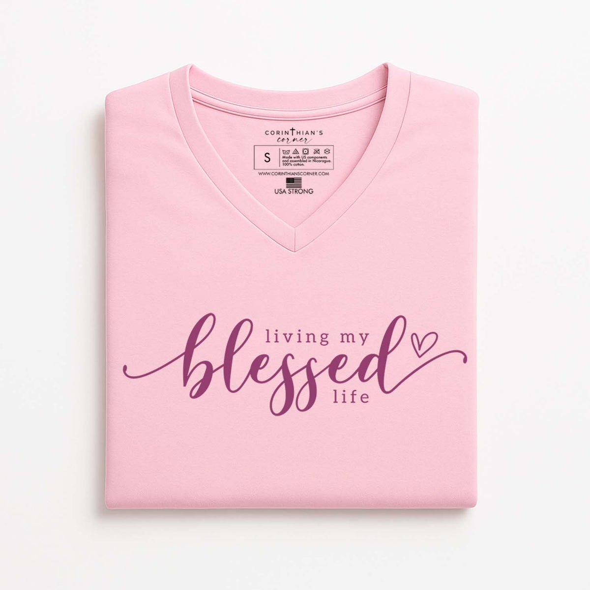 Pink t-shirt with 'living my blessed life' text on a white background