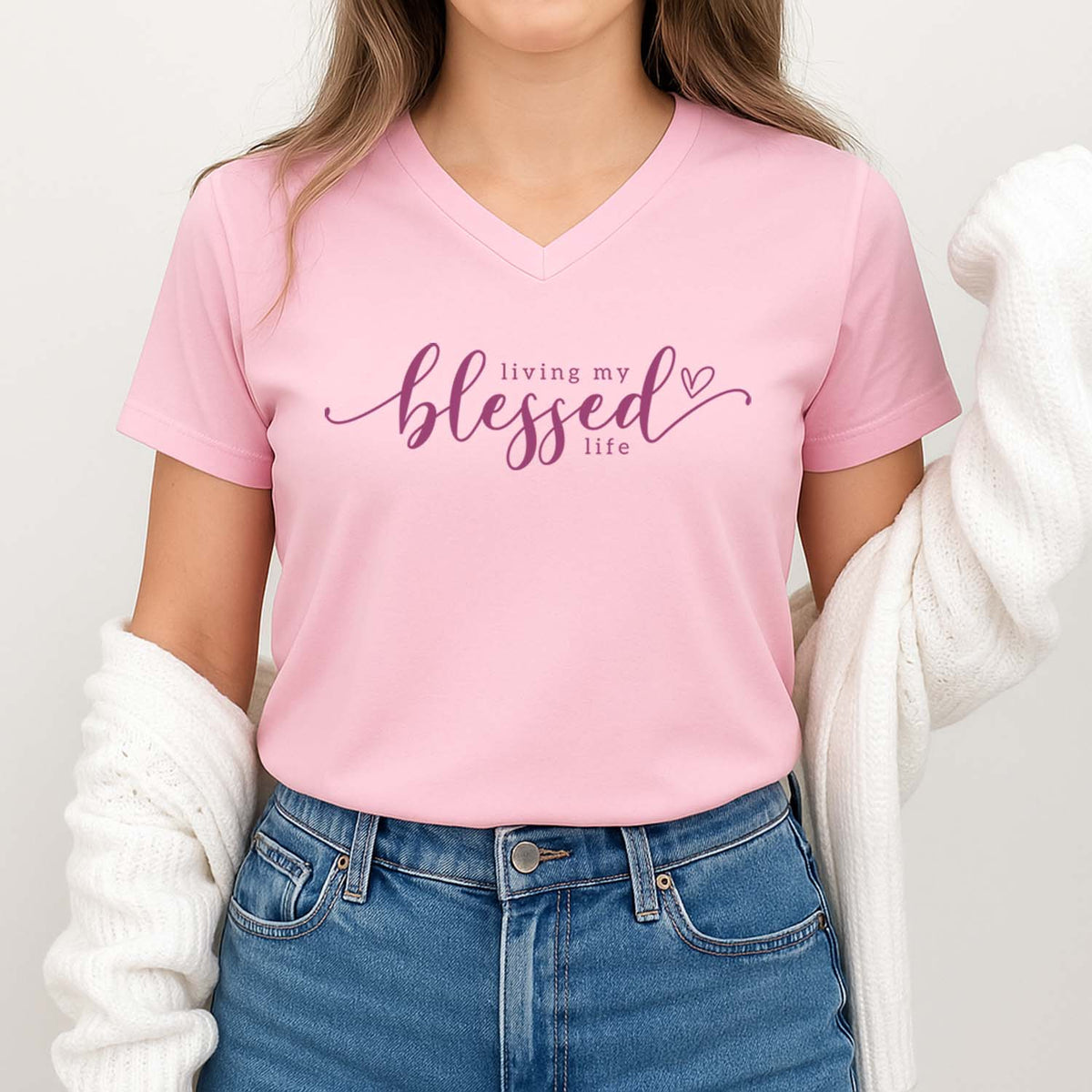 Person wearing a pink t-shirt with 'living my blessed life' text