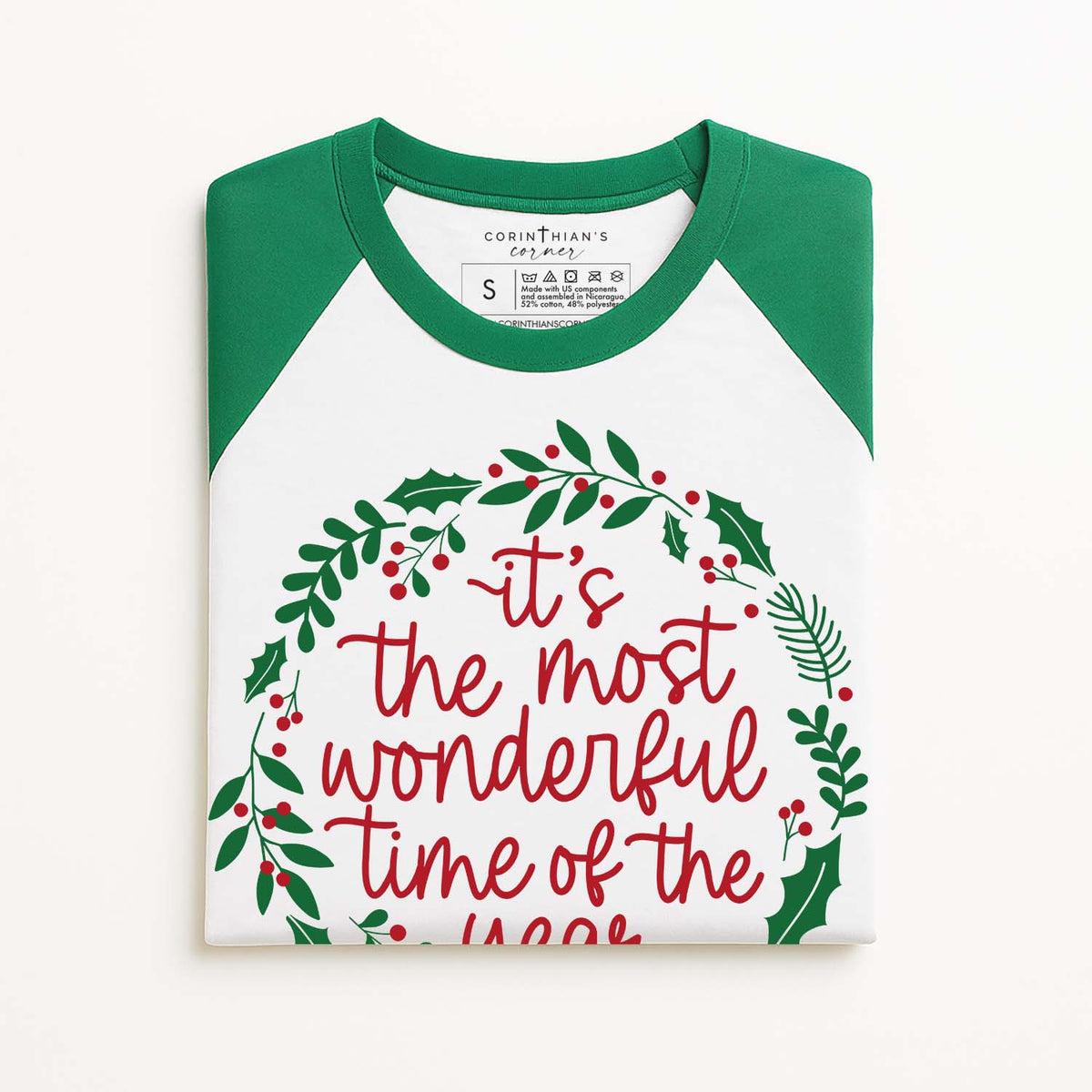 Christmas-themed t-shirt with green sleeves and festive text on a white background