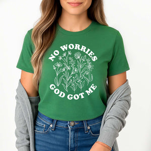 Young lady wearing a green t-shirt with 'No Worries God Got Me' text and floral design.