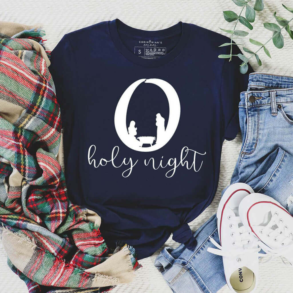 O Holy Night design contains a manger scene on this premium navy Christmas t-shirt