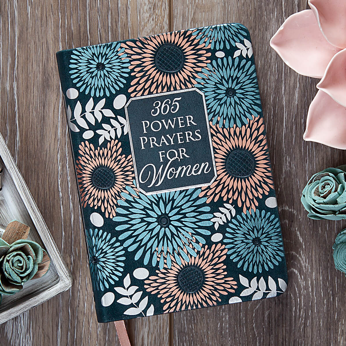 Decorative notebook with floral patterns and text on a wooden surface