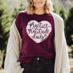 Smiling blonde model wearing a practice gratitude t-shirt in maroon