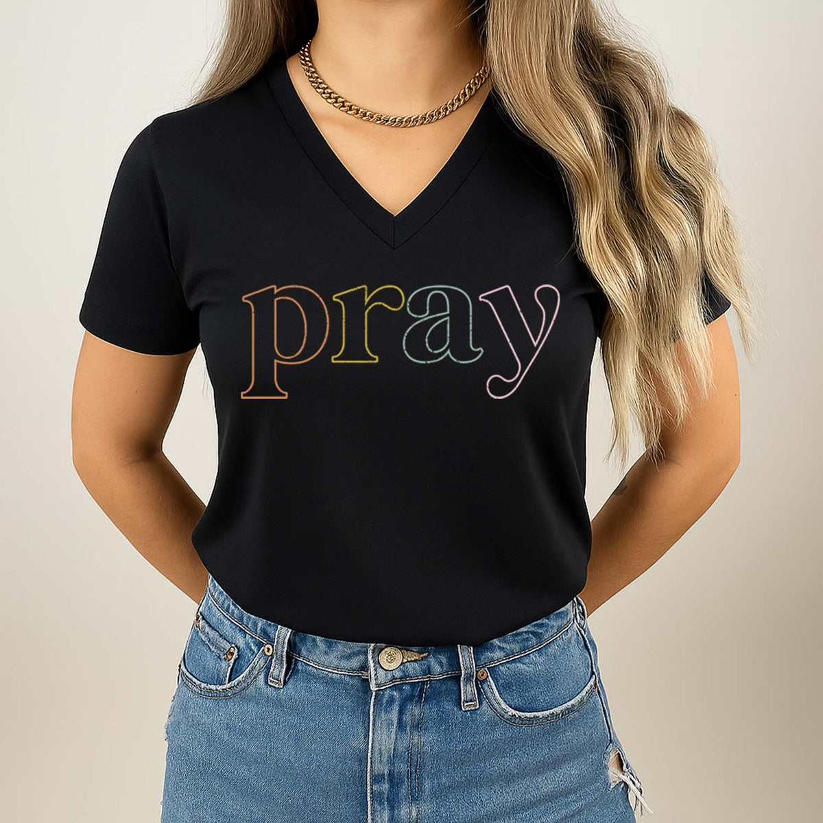 Woman wearing a black t-shirt with 'pray' printed in colorful letters on a plain background