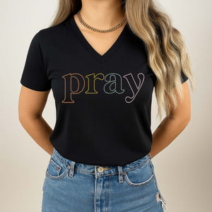 Woman wearing a black t-shirt with 'pray' printed in colorful letters on a plain background