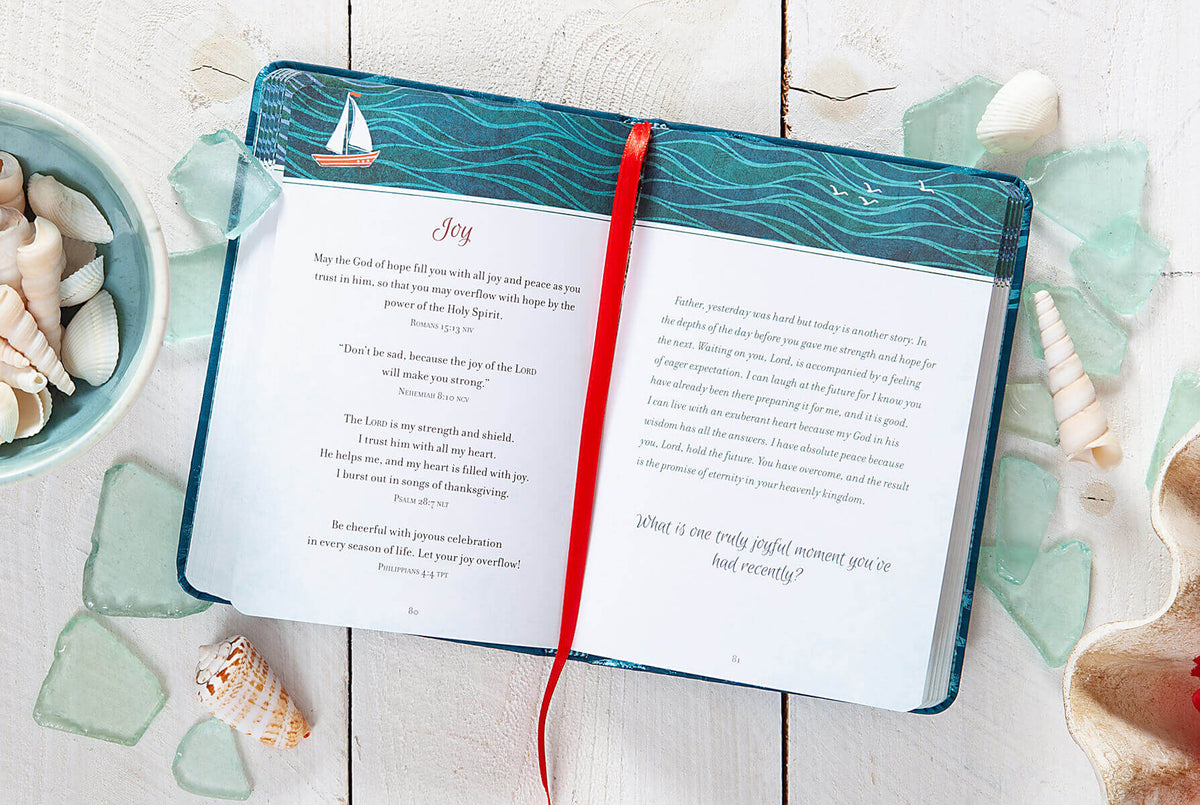 Open book with a red ribbon on a wooden surface with seashells