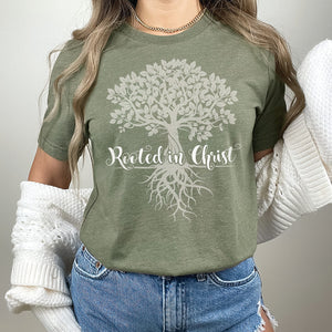 Closeup of a model wearing the green rooted in Christ graphic t-shirt