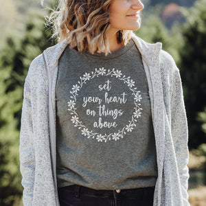 Model in an outdoor setting wearing the light grey set your heart on things above t-shirt