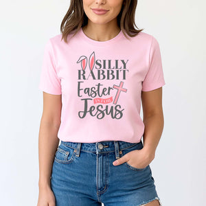 Young woman wearing a pink t-shirt with 'Silly Rabbit Easter is for Jesus' text and graphics.