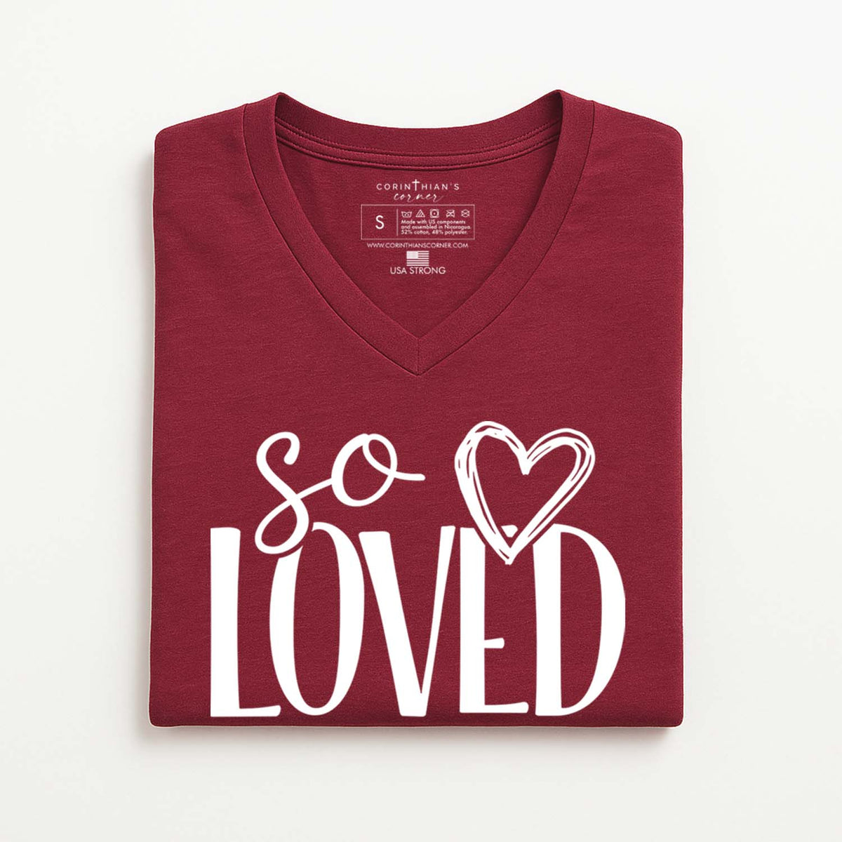 Folded maroon t-shirt with 'so loved' text and heart design on a white background