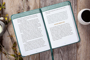 Open book on a wooden surface with a cup of coffee and decorative elements.