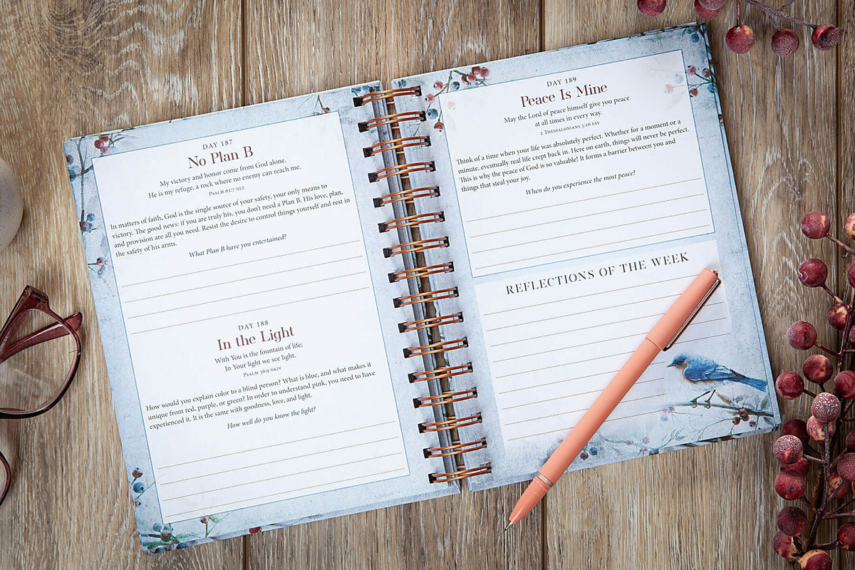 An open spiral-bound journal or planner spread on a wooden surface, showing printed pages titled 'No Plan B,' 'Peace Is Mine,' and 'Reflections of the Week,' with a peach pen resting on the right page. Decorative glasses and red berries are partially visible around it.