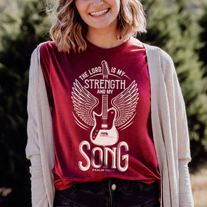 The Lord is my strength and my song rock-inspired t-shirt on a smiling young woman