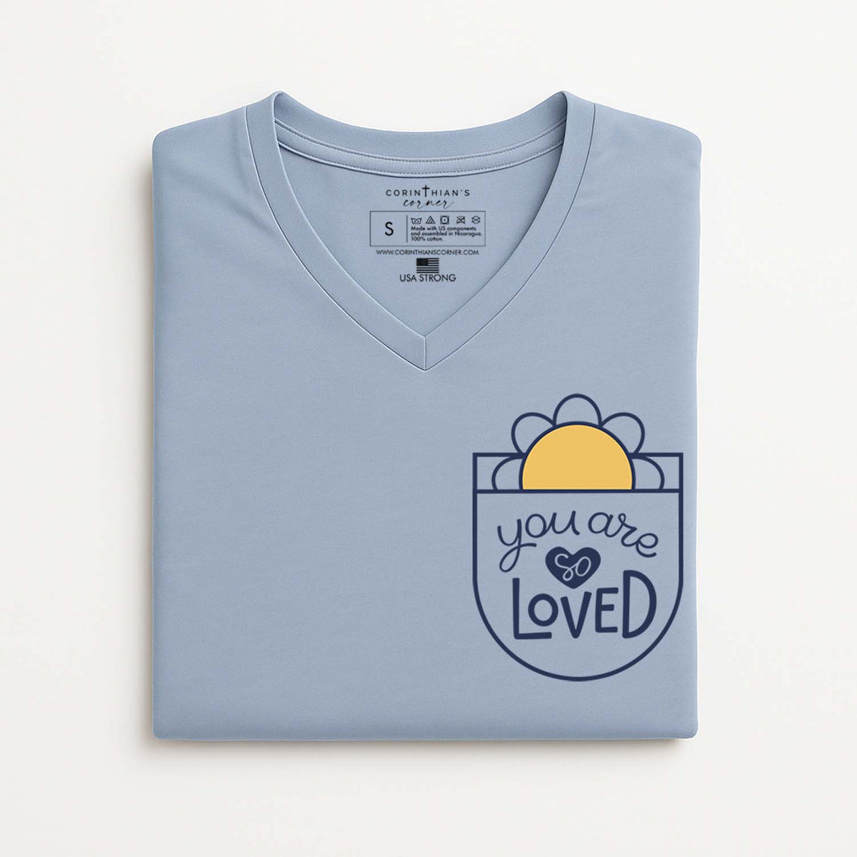 Folded light blue t-shirt with 'you are loved' design on a white background