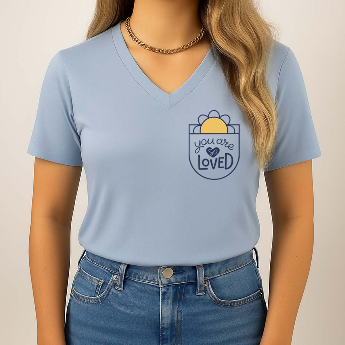 Woman wearing a light blue t-shirt with a graphic design that reads you are so loved