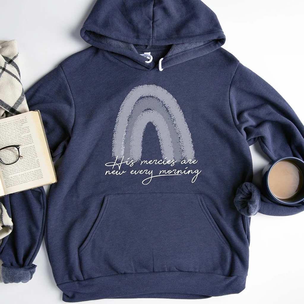 Navy blue hoodie with a two tone rainbow design and an inspiring cursive statement "His mercies are new every morning"