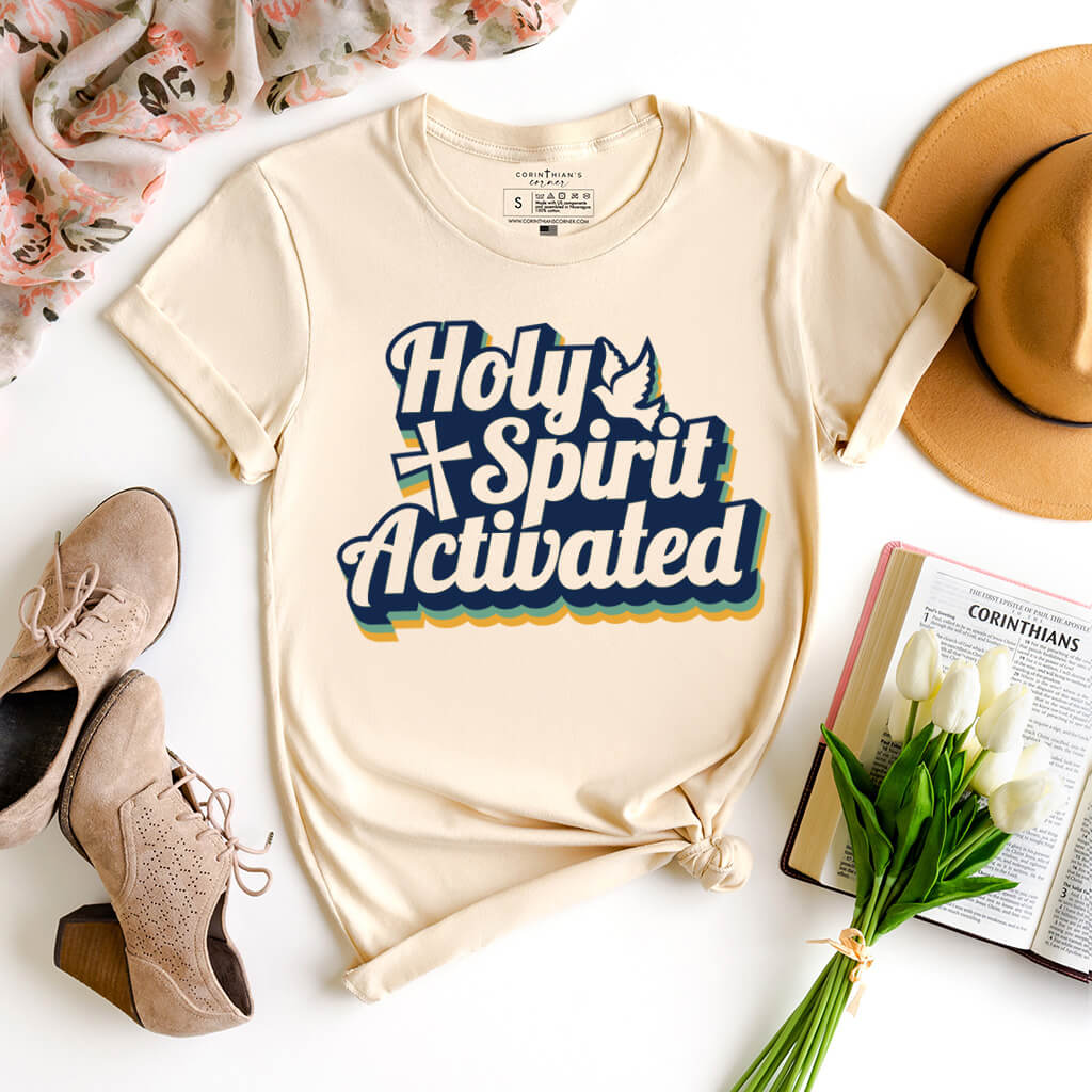 Multi-color Christian design that reads Holy Spirit Activated on a cream t-shirt