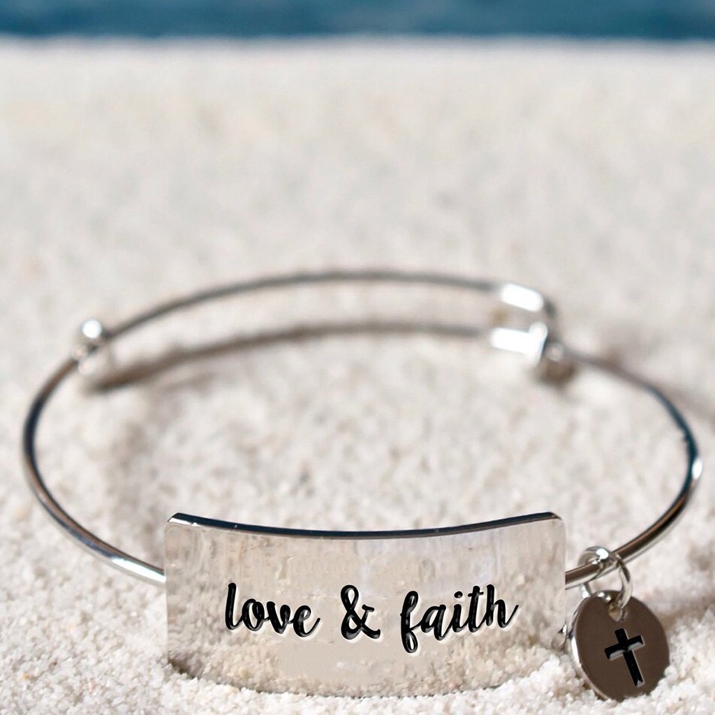 Stainless steel bracelet with horizontal plate that reads "love & faith"