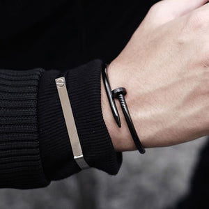 Man in black jacket wearing a nail bracelet around his wrist
