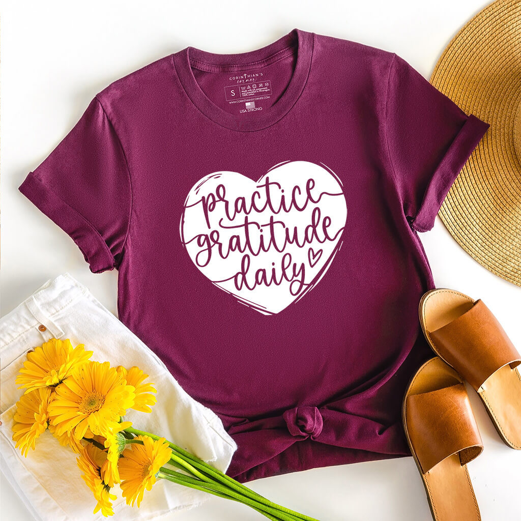 Uplifting shirt in maroon that reads practice gratitude daily