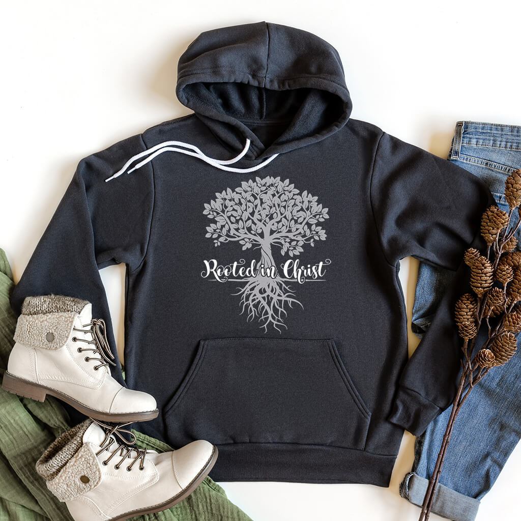 Rooted in Christ dark grey hoodie styled with jeans and light boots